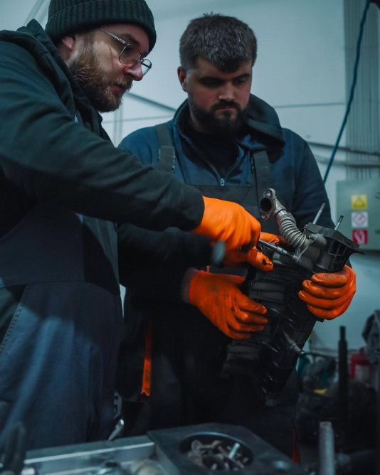 mecanic de încredere explicând clientului reparația în service auto